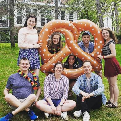 student posing with giant pretzel at Maifest